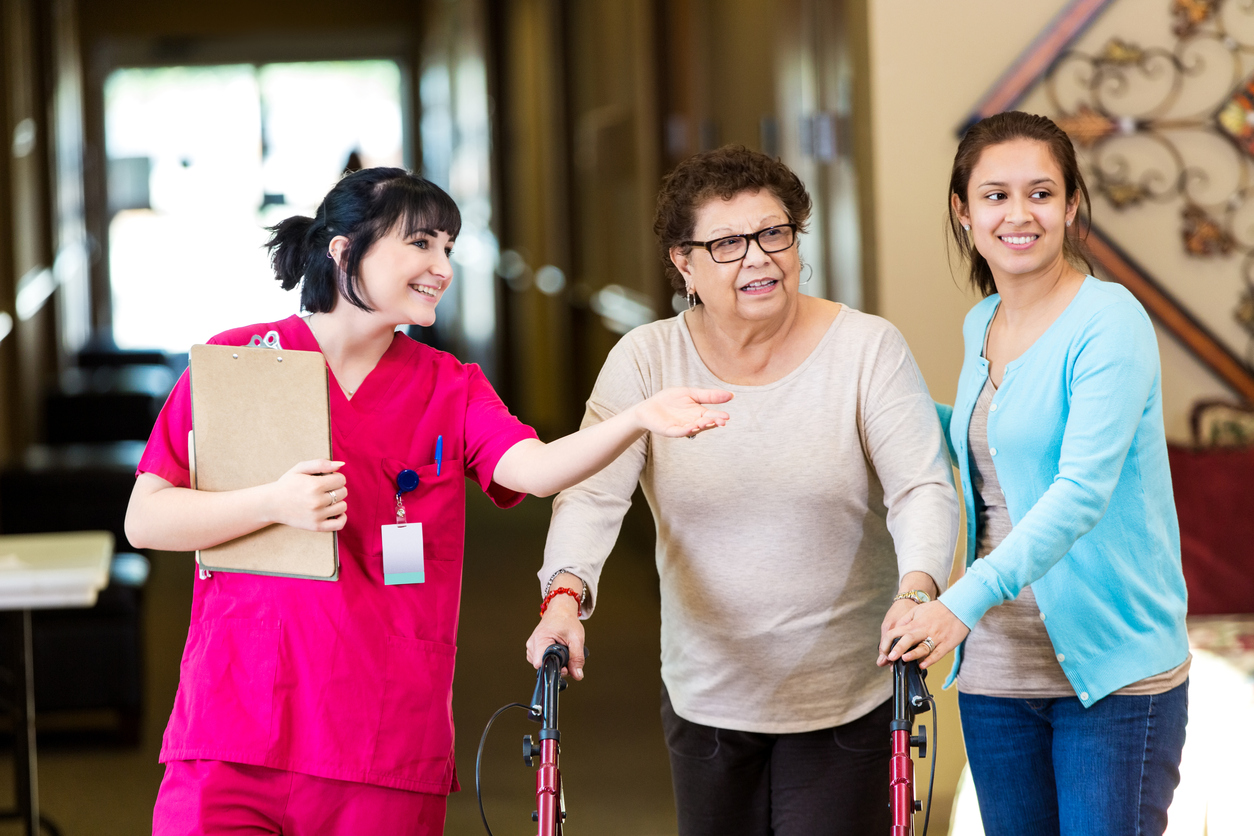 Nurse shows senior woman around in assisted living facility